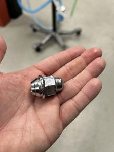 A lug nut held in one hand.